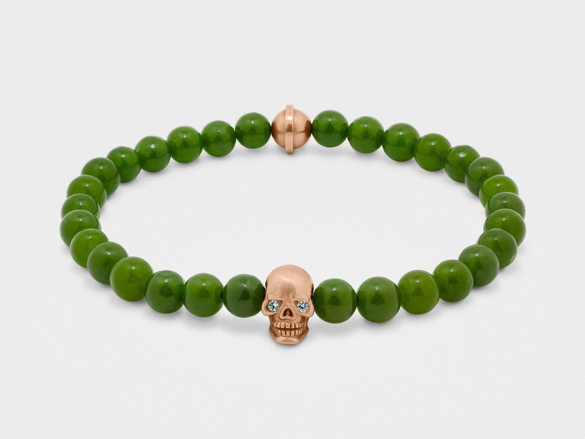 Totenkopf-Armband in Gold mit klaren Augen und grünen Perlen